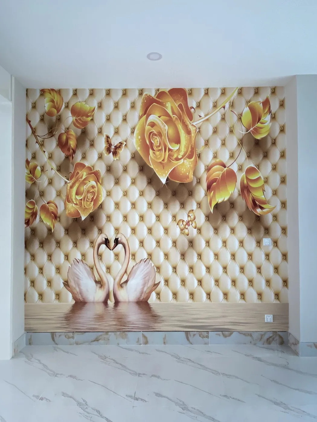 An MK-3D printed mural of gold roses and two swans on a quilted wall