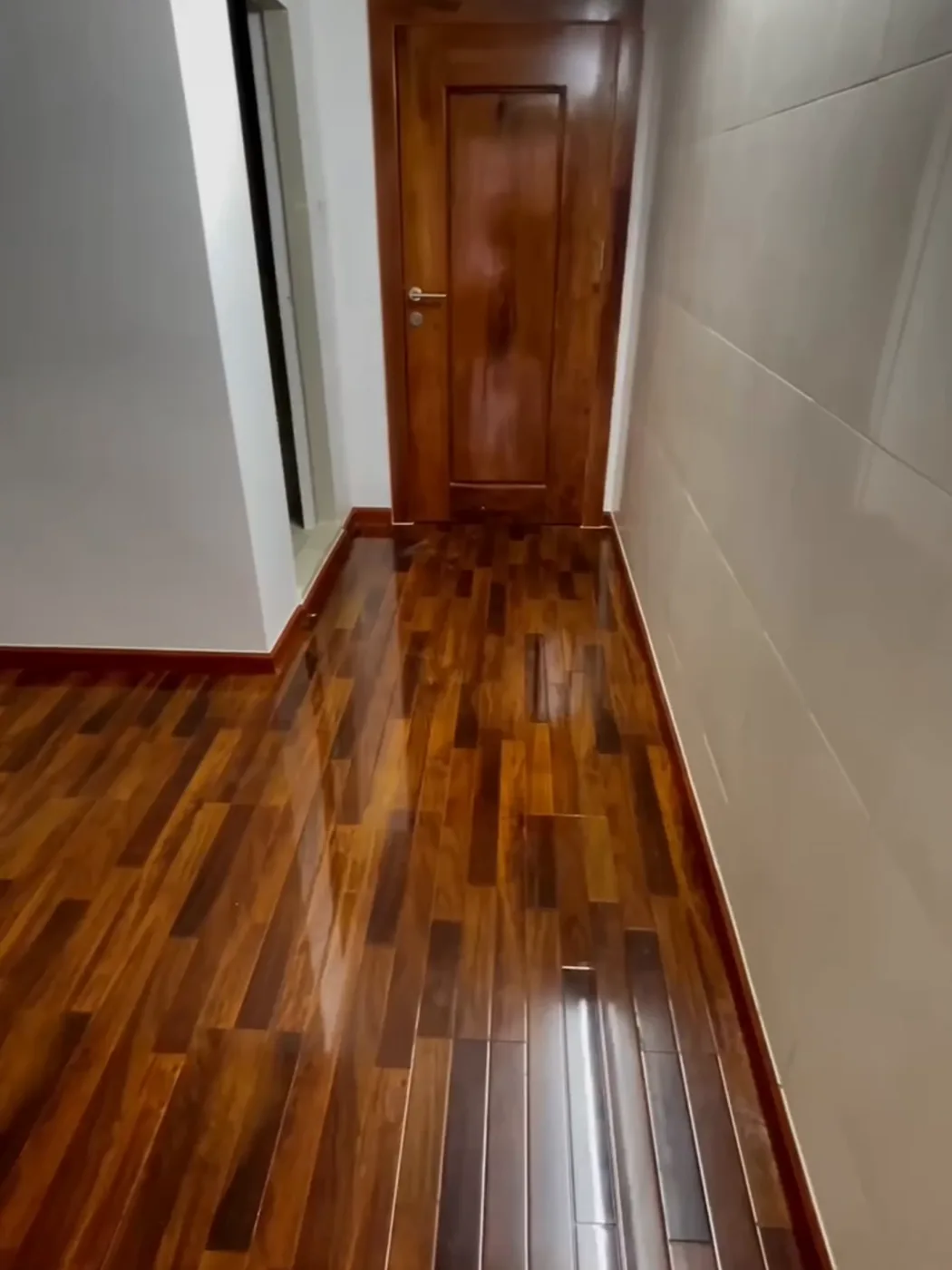 Glossy dark wood parquet and a matching wooden door, laid by MK Decor in a Phnom Penh home